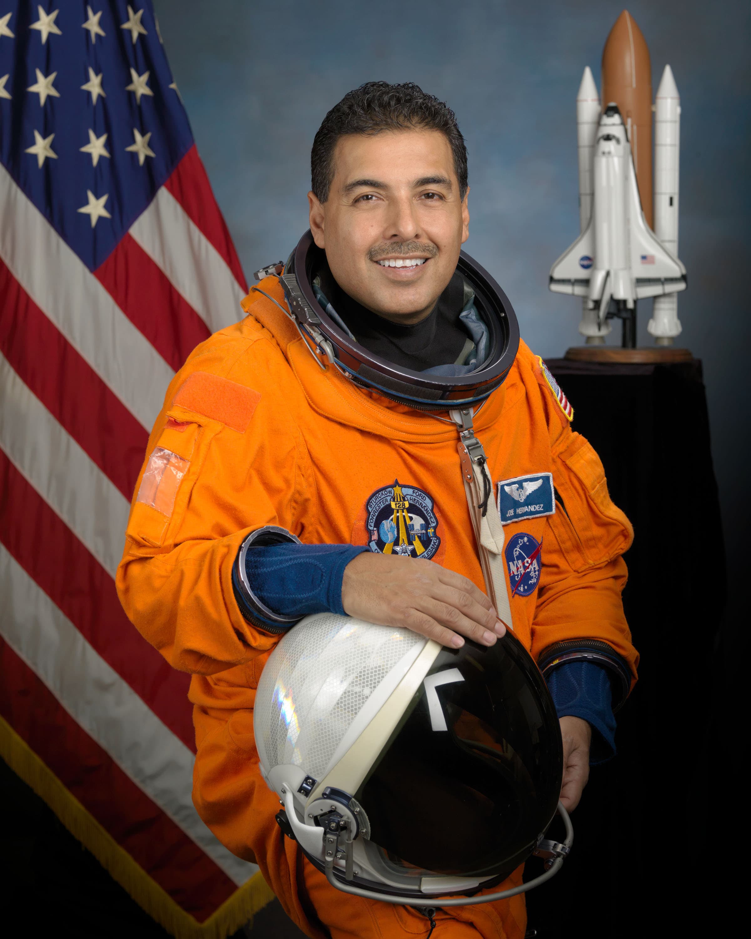 Official NASA portrait of astronaut José M. Hernández in a blue flight suit.